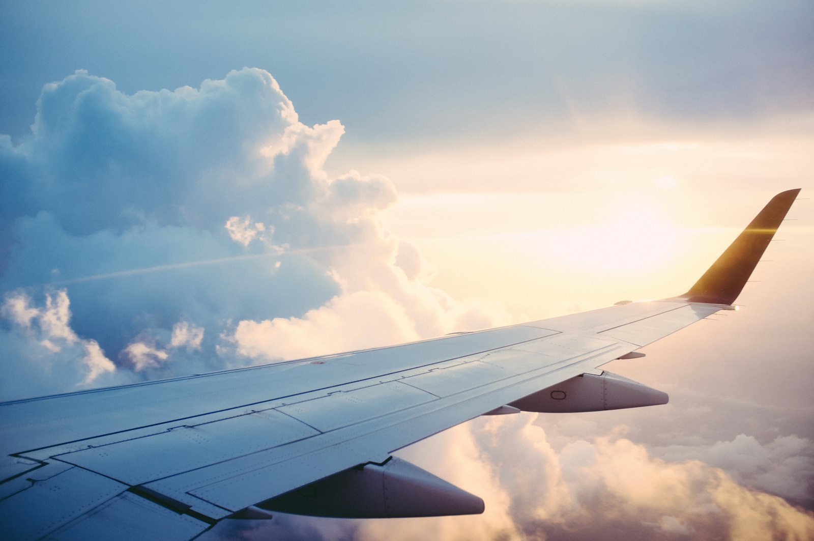 Aircraft wing above the clouds, international business travel